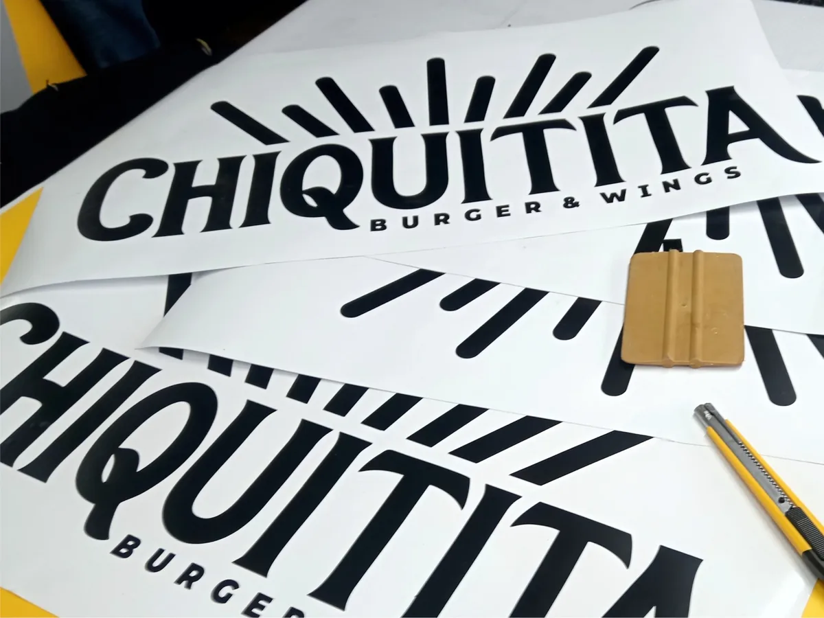 Calcomanías de vinil cortadas con el logo de un restaurante, con espátula y cutter