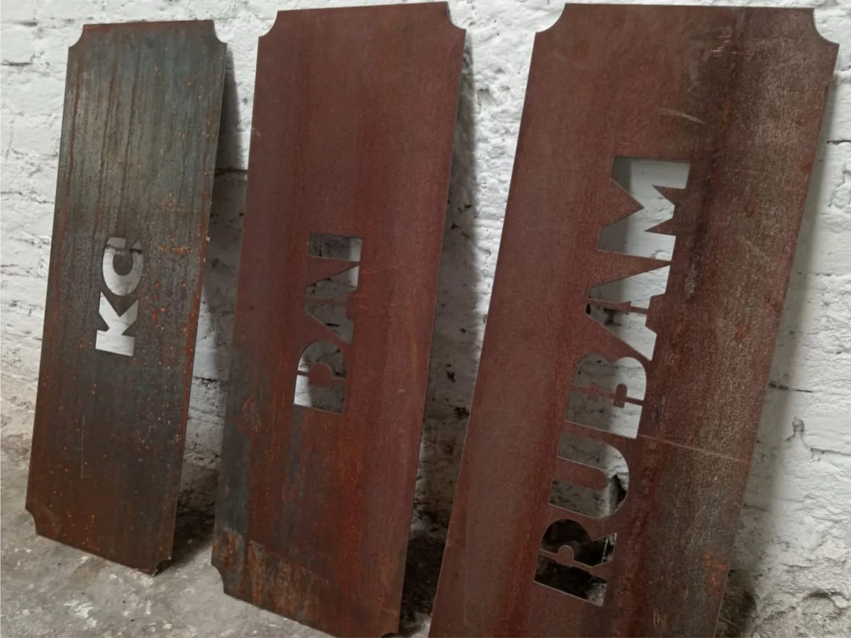 Placas de acero oxidado con letras cortadas en plasma